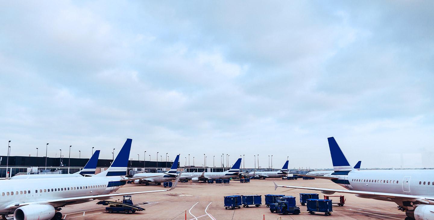 View of seven planes parked at their gates at an airport
